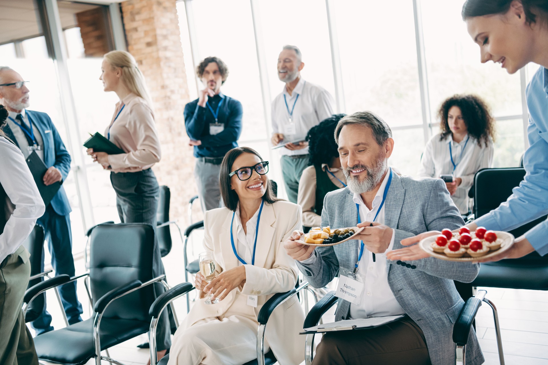 Professional people networking and sharing refreshments at a corporate business event in a modern office setting